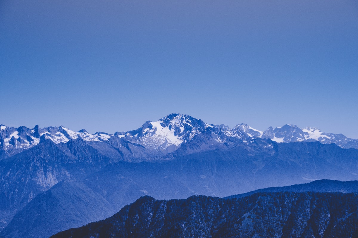 Aerial view of glacier-capped mountains stretching to the horizon