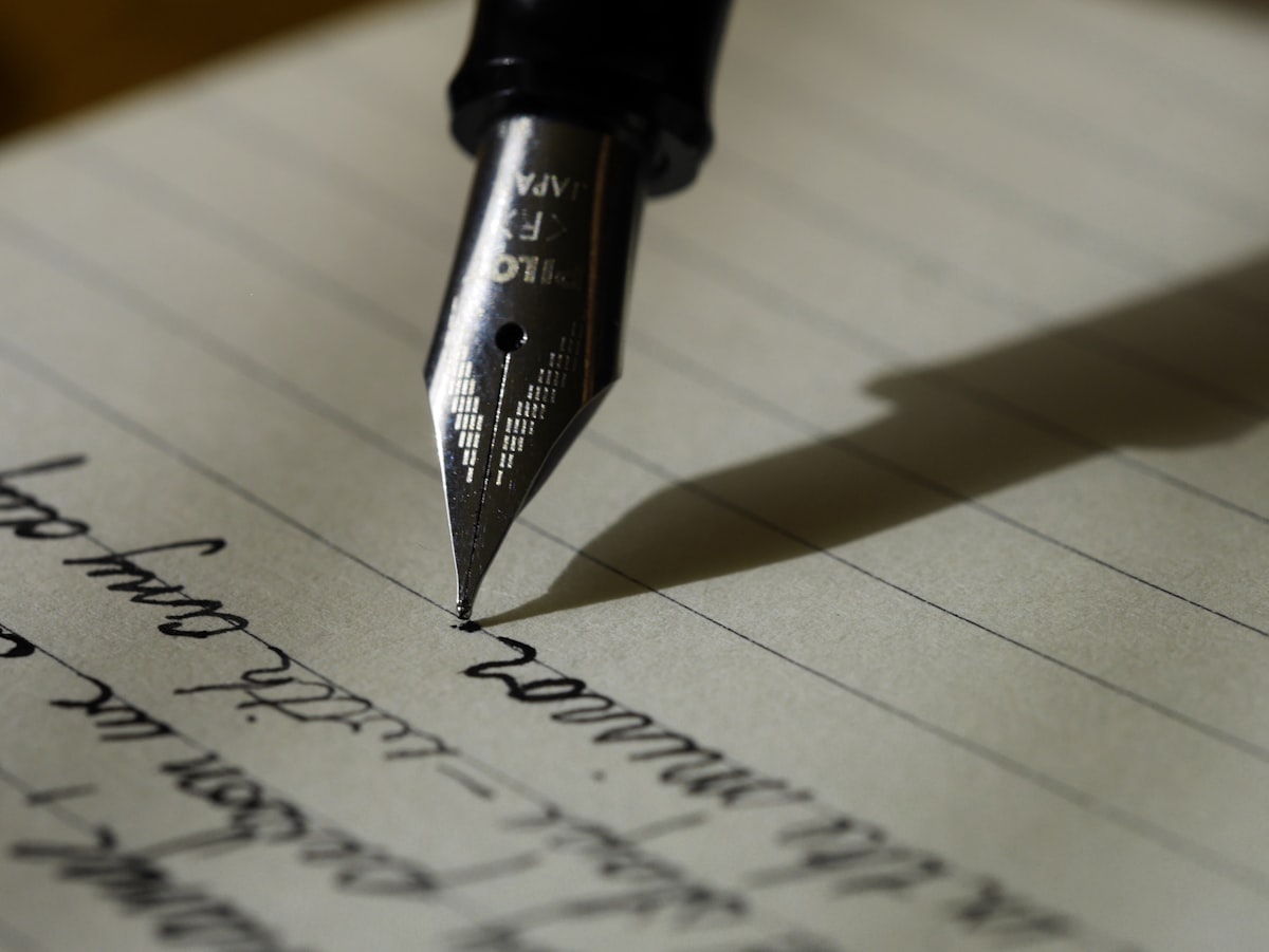 A typewriter with a blank page loaded, morning light through a window, an ashtray nearby