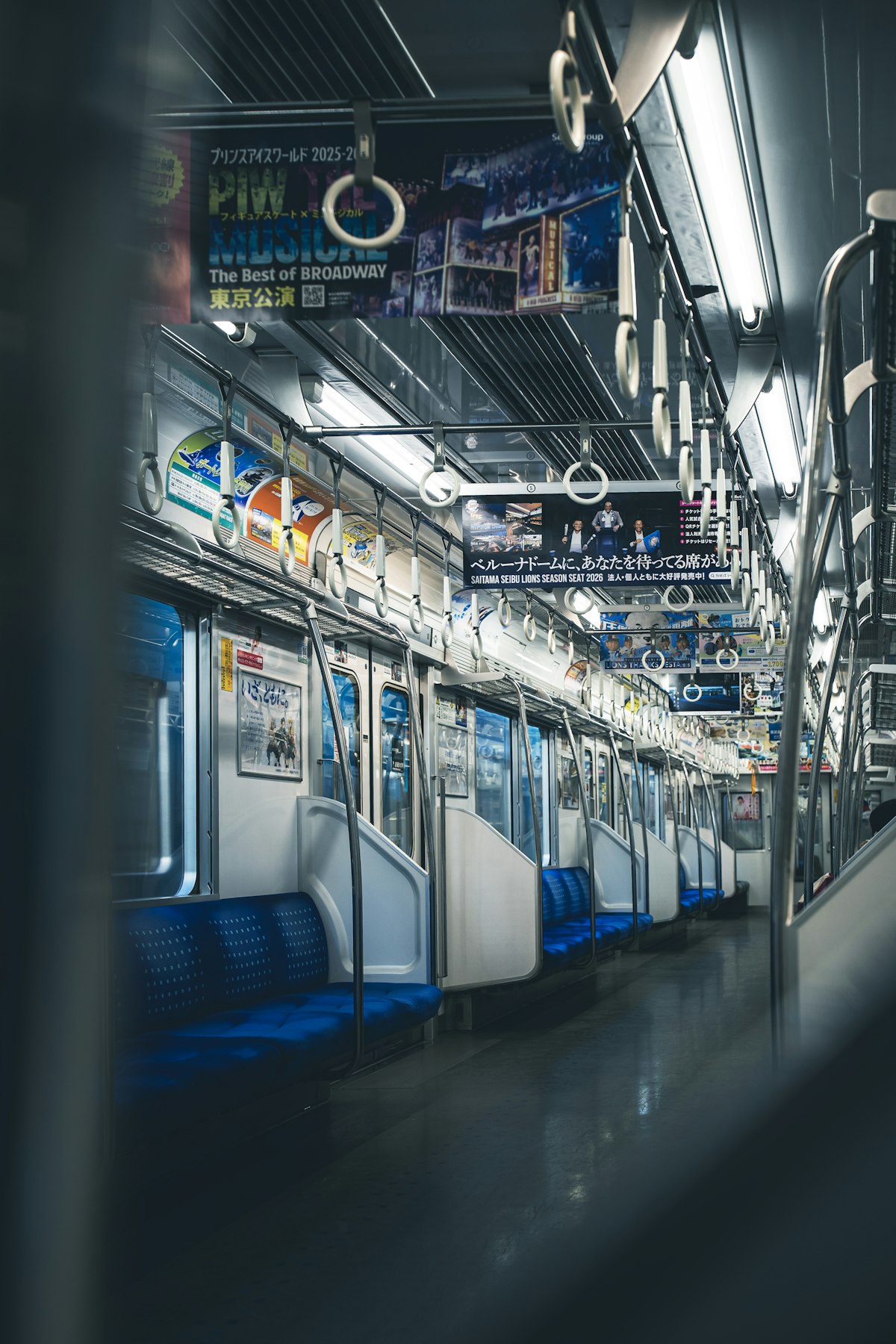 Interior of an empty subway train car with rows of open seats