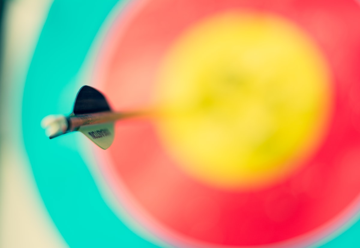 Close-up of an arrow striking the center of an archery target